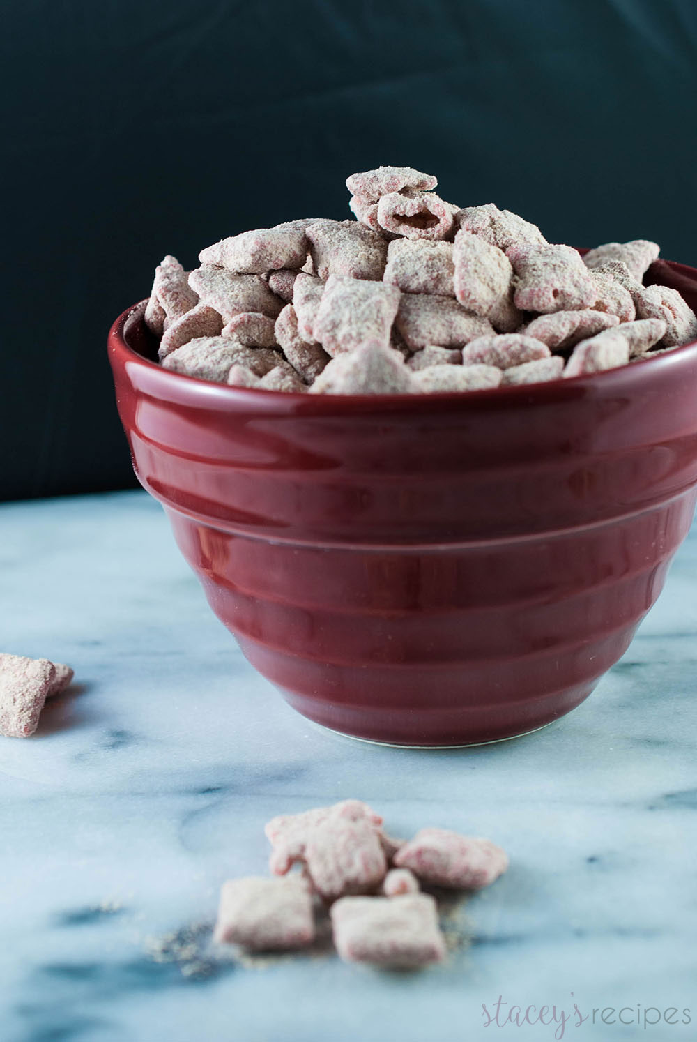 Crunchy Muddy Buddies coated in red candy melts and white chocolate, tossed in red velvet cake mix! An addictive snack - you won't be able to stop! | www.staceysrecipes.com
